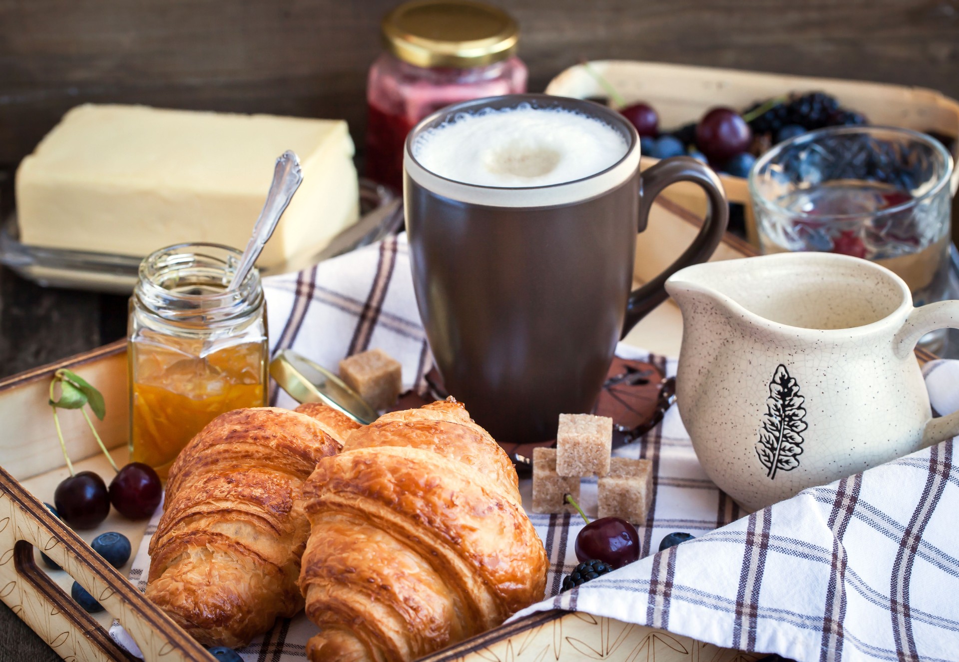 Petit déjeuner avec des croissants et de la confiture, cappuccino
